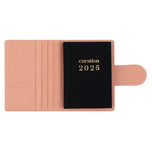 Compendium flamingo pink colour with Curation 2025 diary inside