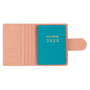 Compendium flamingo pink colour with Curation 2025 diary inside