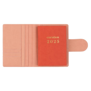 Compendium flamingo pink colour with Curation 2025 diary inside